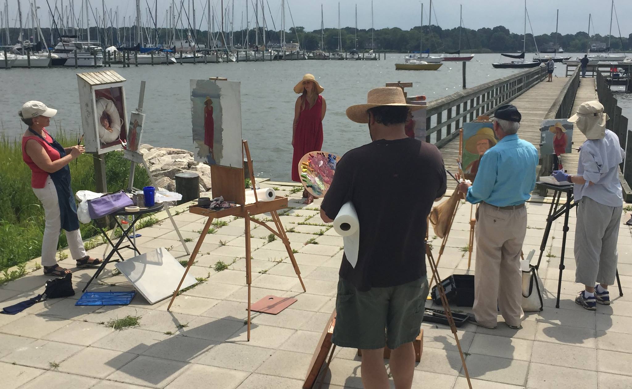 artist painting a model by the water